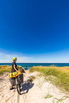 Cyclist with e-bike on baltic sea coast path in Wustrow Germany