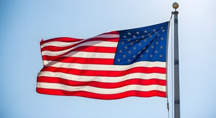 The american flag waving proudly in the wind against a clear blue sky, a symbol of patriotism and freedom