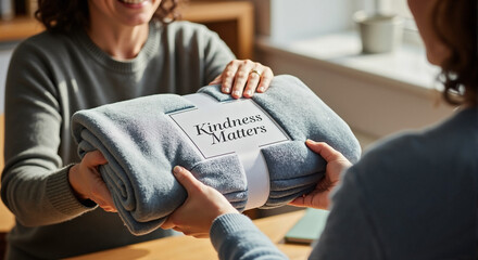 Kindness matters, demonstrated by giving packaged blanket to another person. Spreading kindness is essential to show concern to another person, making positive impact. 