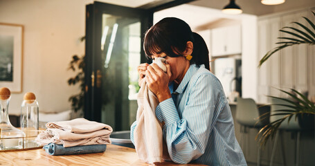 Woman, smell laundry and fold in home with hygiene, scent and organize with chores for routine....