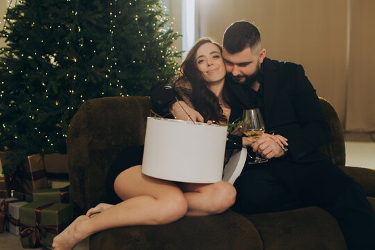 Couple celebrating christmas with gift and wine
