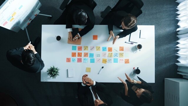 Top down aerial view of businessman report sales to project manager while startup team clapping hands to celebrate increased profit at meeting room. Group of manager finding a solution. Directorate.