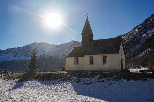 Maso Corto mountain village with chapel during winter, Italy