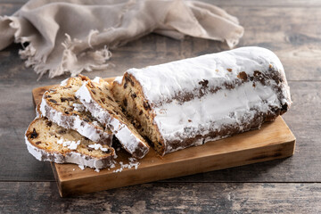 Traditional Christmas Stollen with Raisins and Powdered Sugar on wooden table