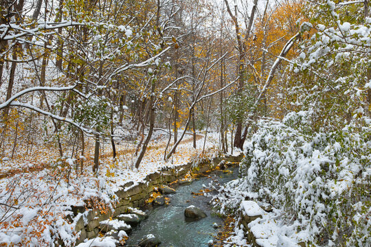 Autumn forest with river and snow covered footpath