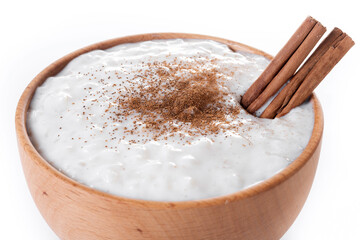 Rice pudding on wooden bowl isolated on white background. Close up