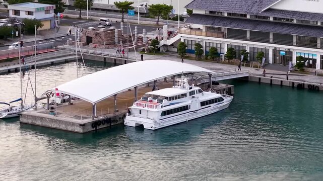 【日本の観光】青空の港に停泊するフェリー・遊覧船のドローン空撮（右旋回）