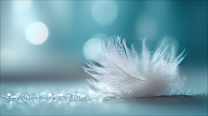 Obraz premium White feather resting on a glittery surface, creating a dreamy teal and turquoise aesthetic with soft bokeh illumination