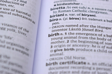 Obraz premium Close Up Of English Dictionary Page With Word - birth