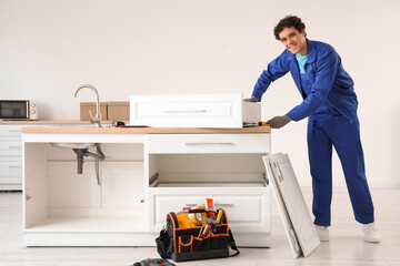 Male worker assembling drawer in kitchen