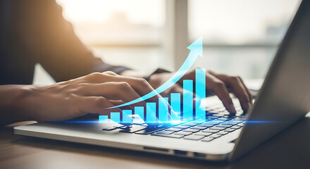 Hands typing on laptop keyboard with rising graph overlay, indicating growth and business success