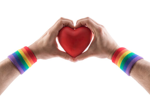 Red heart in hands with colorful rainbow LGBT wristband isolated on white background with clipping path.