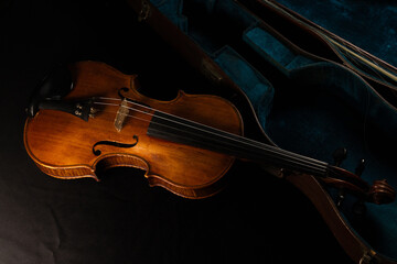 Fototapeta premium vieux violon posé sur un bel étui ancien de couleur bleu vert.