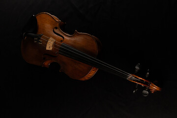 Fototapeta premium vieux violon posé sur une table recouverte d'un tissu noir