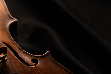 gros plan sur un vieux violon en bois, sur fond noir avec place pour mettre du texte