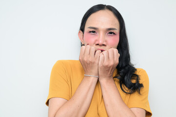 Studio portrait of a young Thai transgender person in 20s looking scared and biting nails
