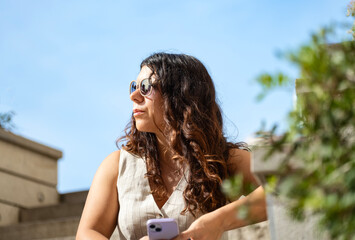 Woman with cell phone sitting on urban steps