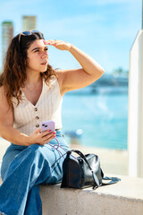 Woman with cell phone shielding herself from the sun