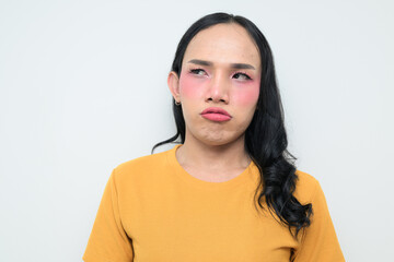 Fototapeta premium Portrait of a young Thai transgender person against white background looking bored and tired