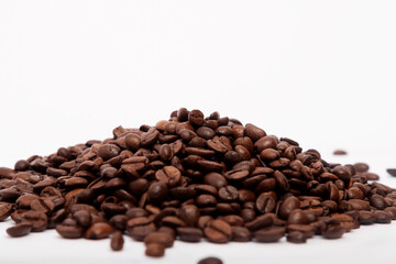 Pile of roasted coffee beans on white background