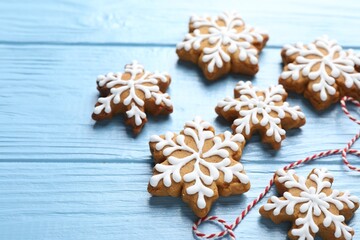 Tasty gingerbread cookies on light blue wooden background, closeup. Christmas treat