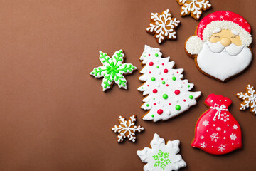 Tasty gingerbread cookies on brown background, flat lay with space for text. Christmas treat