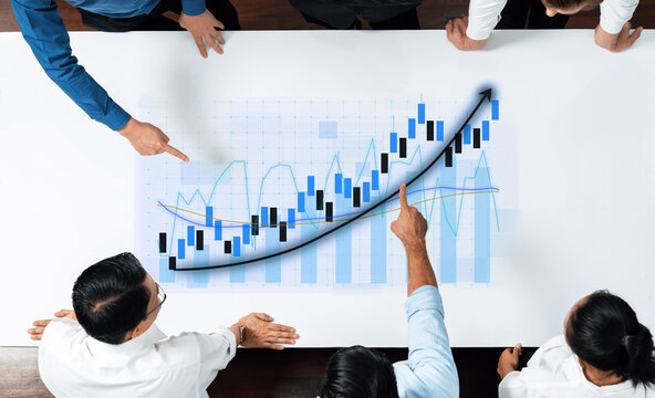 A diverse team of professionals engages in a strategic analysis of financial data, reviewing charts and graphs to devise plans for business growth and success. Axiom - Powered by Adobe