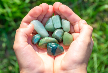 Natural mineral jade in hands on natural background © Elena