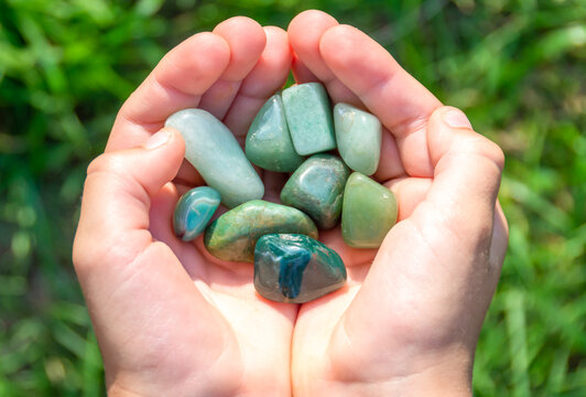 Natural mineral jade in hands on natural background