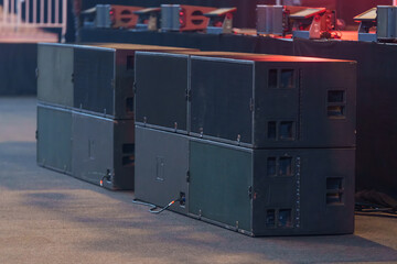 Large professional speakers positioned on the venue floor for powerful live sound during events