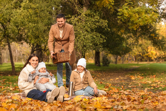 Happy family having picnic in autumn park