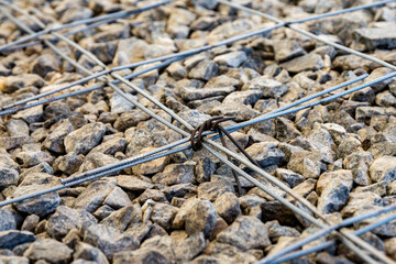 Close-up of steel reinforcement mesh laid on crushed stone for concrete slab foundation