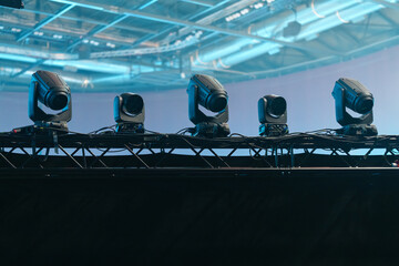 Industrial stage lighting mounted on aluminum frames inside the venue, prepared to illuminate the live performance area