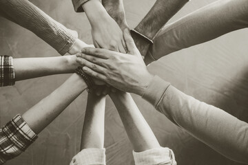 People holding hands together indoors, top view. Unity concept