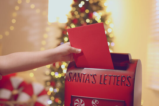 Merry Christmas and Happy Holidays. Child putting letter into Santa's mailbox on greeting card