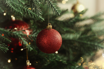 Merry Christmas and Happy Holidays greeting card. Christmas tree with balls and string lights, closeup