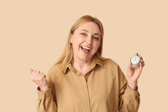 Happy mature woman with stopwatch on beige background - Powered by Adobe
