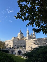 Narrow street lined with buildings leading to Almudena Cathedral in the background