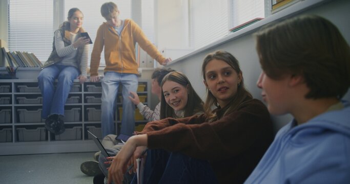 Students Sit Together on Floor Around Laptop, Sharing Ideas and Writing Notes During Collaborative Study Session. Concept Peer Learning, Open Dialogue, and Flexible Modern Classroom Environment.