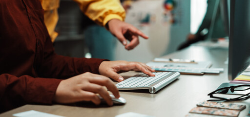 A modern workspace featuring hands typing on a keyboard, embodying collaboration and creativity....