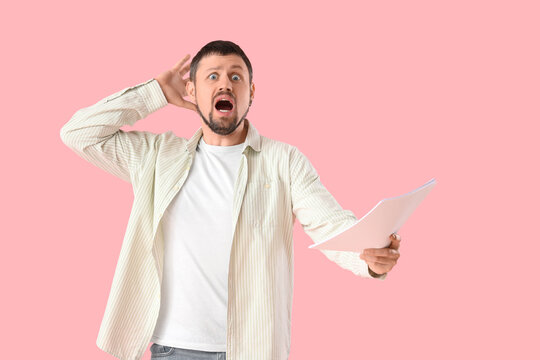Shocked male actor with film script on pink background - Powered by Adobe