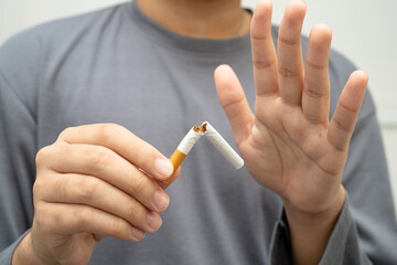 Quit smoking, Asian teenage man breaking destroy cigarette in hand.
