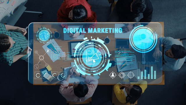 A top-down view of professionals engaged in a digital marketing strategy session, featuring a futuristic technology interface overlaid on their collaborative workspace. Trope - Powered by Adobe