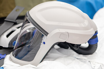 A white protective helmet with a transparent screen is used to filter the air.
