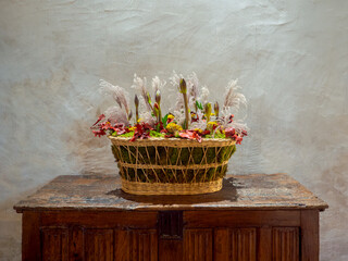 Floral arrangement in a wicker basket on a wooden table