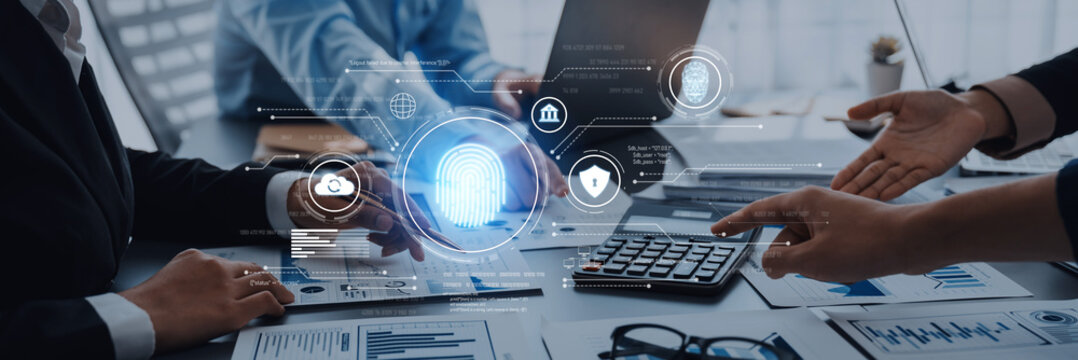 A professional meeting showcasing technology and data security discussions with a digital interface, financial documents, and active collaboration among team members. Trope