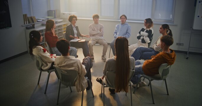Teacher Facilitates Mental Health Discussion With Teenagers in Bright Classroom, Promoting Empathy and Trust. Concept Emotional Growth, Student Support, and Modern School Environment. Dolly Shot.