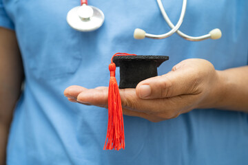 Asian doctor study learn with graduation gap hat in hospital ward, clever bright genius education medicine.