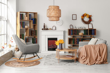 Fototapeta premium Interior of living room with autumn leaves, sofa and bookshelves