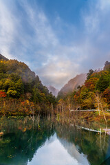 Fototapeta premium 夜明け前の自然湖の水面に映る紅葉